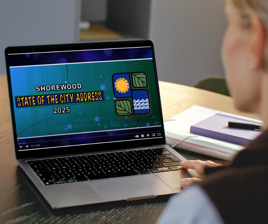 woman looks at laptop that is playing state of city address