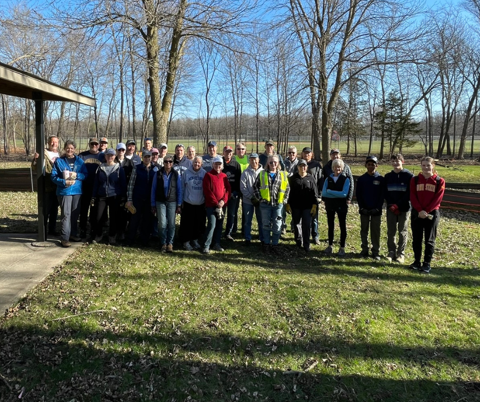 group of about 30 volunteers stand in park