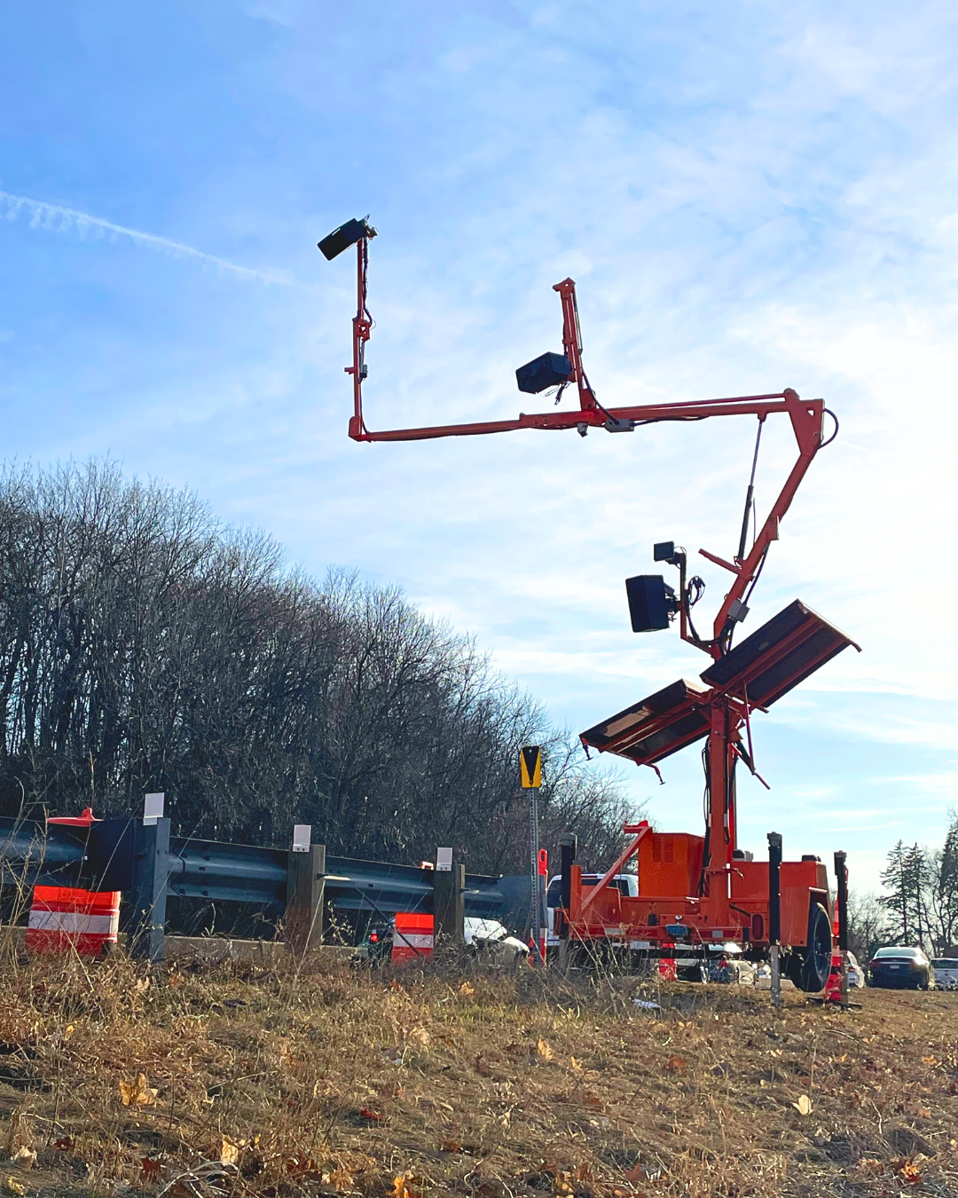 AI camera mounted on orange crane arms hanging over highway 7